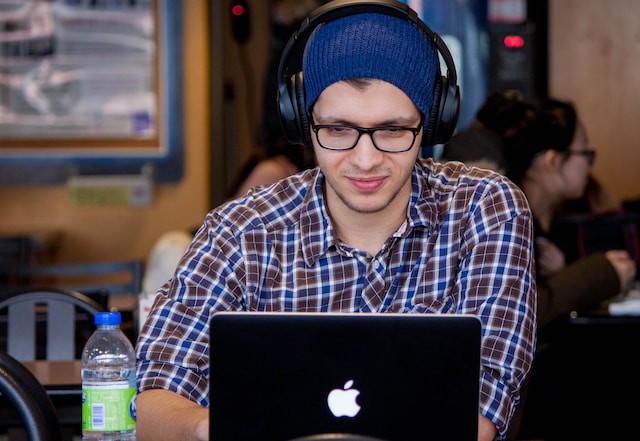 Man playing online slots on his laptop while at a cafe